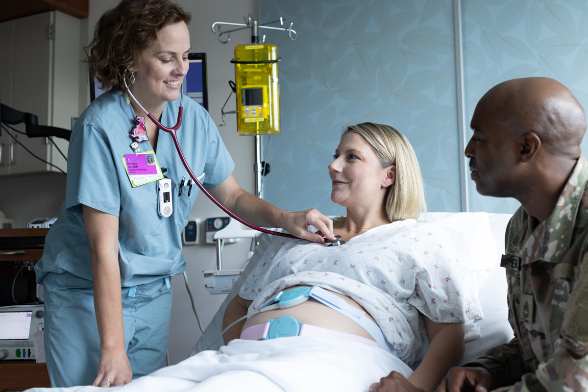 Maternity room image. Military family talks to a nurse.