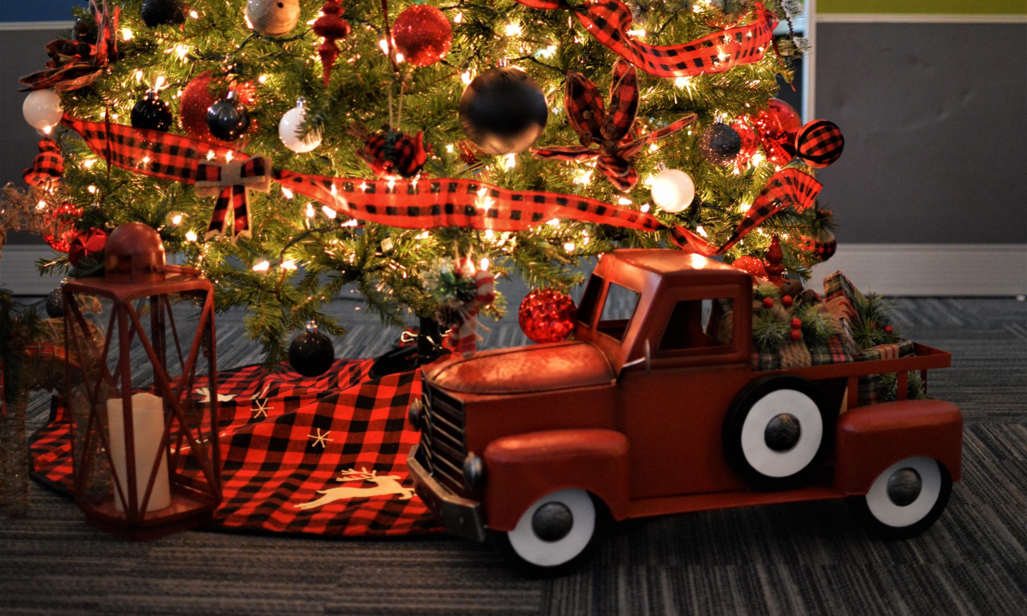 Illustrative image: shows a lit up Christmas tree with a toy truck.