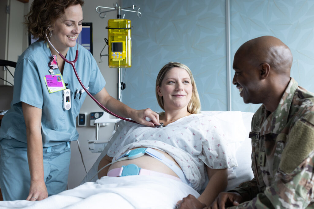 Maternity image shows parents-to-be interacting with a registered nurse. 