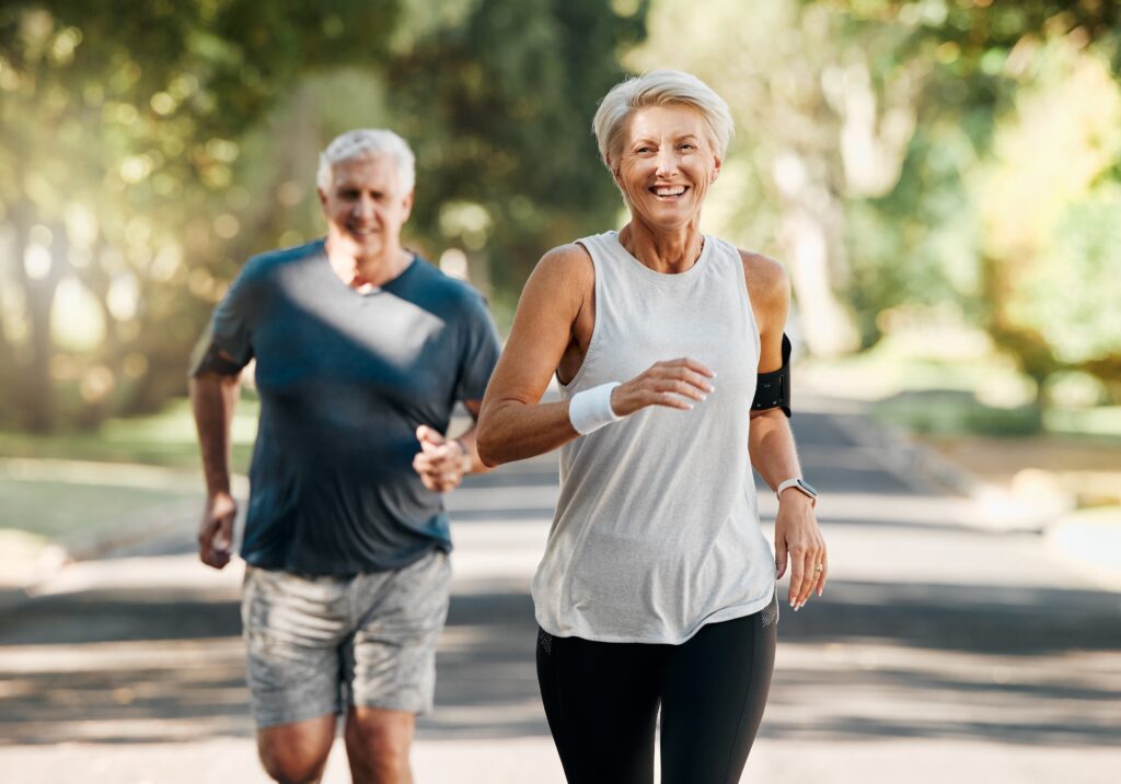 A senior couple is jogging on the road. They look healthy and happy.