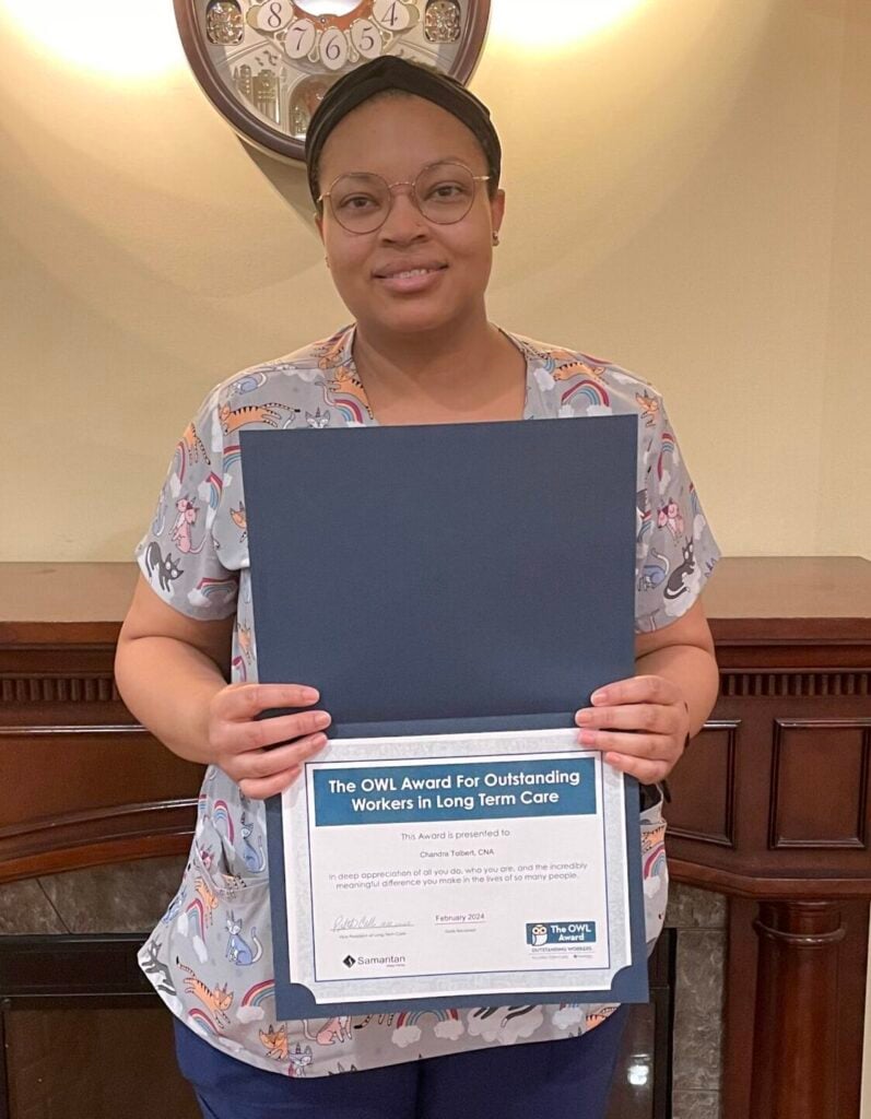 Chandra Tolbert's portrait holding her OWL Award certificate.  