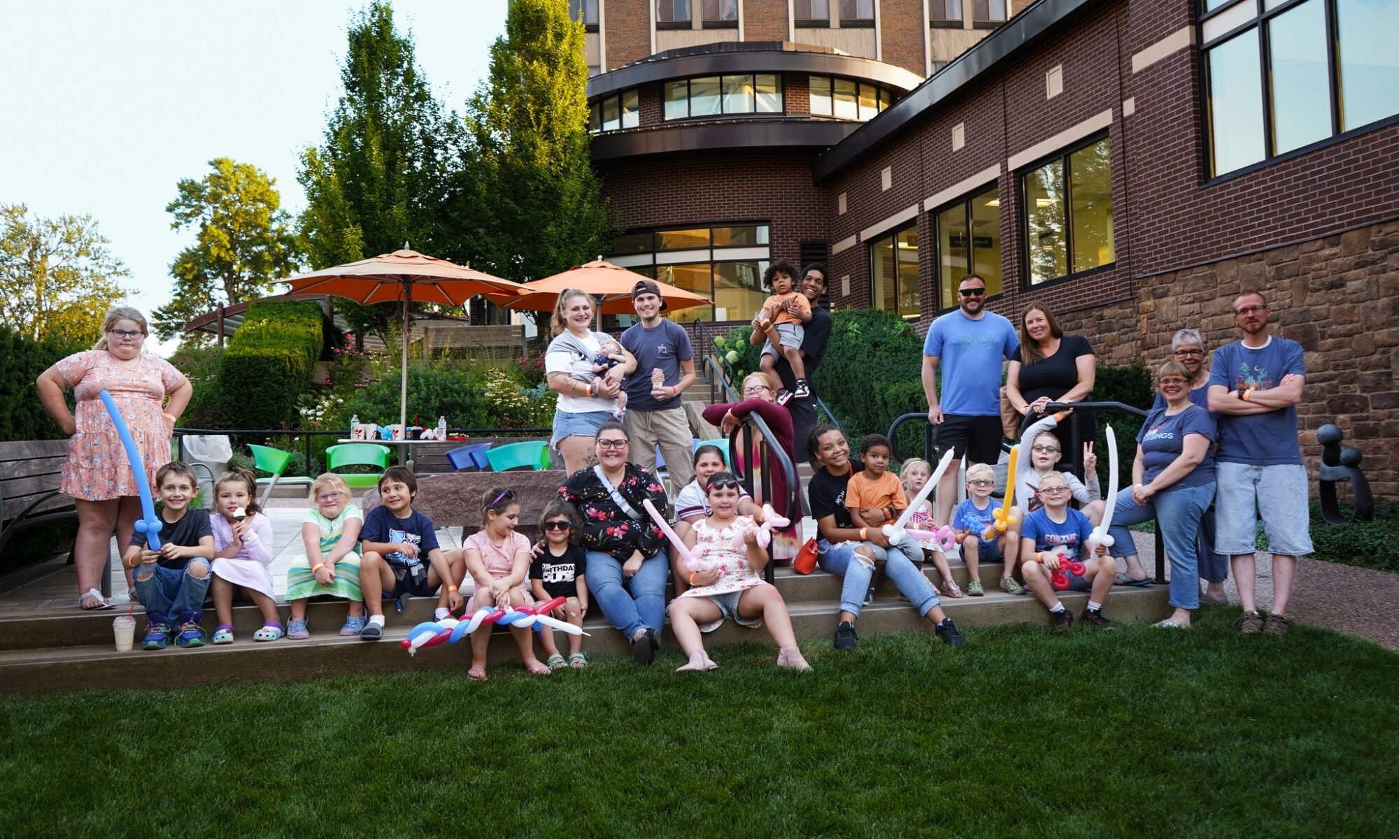 Picture shows kids and adults, Children's Miracle Network of NNY families, sitting at Samaritan's outside garden.