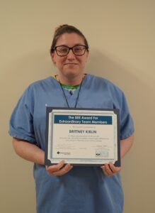 Portrait of Brittney Kiblin, registered pharmacy technician, holding her BEE Award certificate