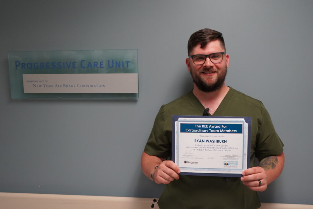 Ryan Washburn, NA, holding his BEE Award Certificate at Samaritan's Progressive Care Unit.