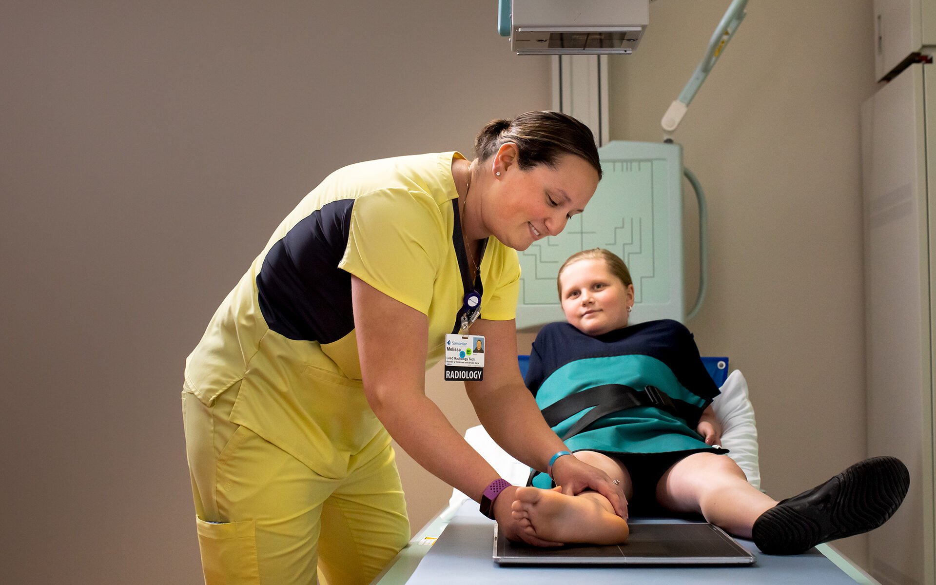 Samaritan Imaging services. Image shows a radiologist adjusting patient's foot for X-ray.