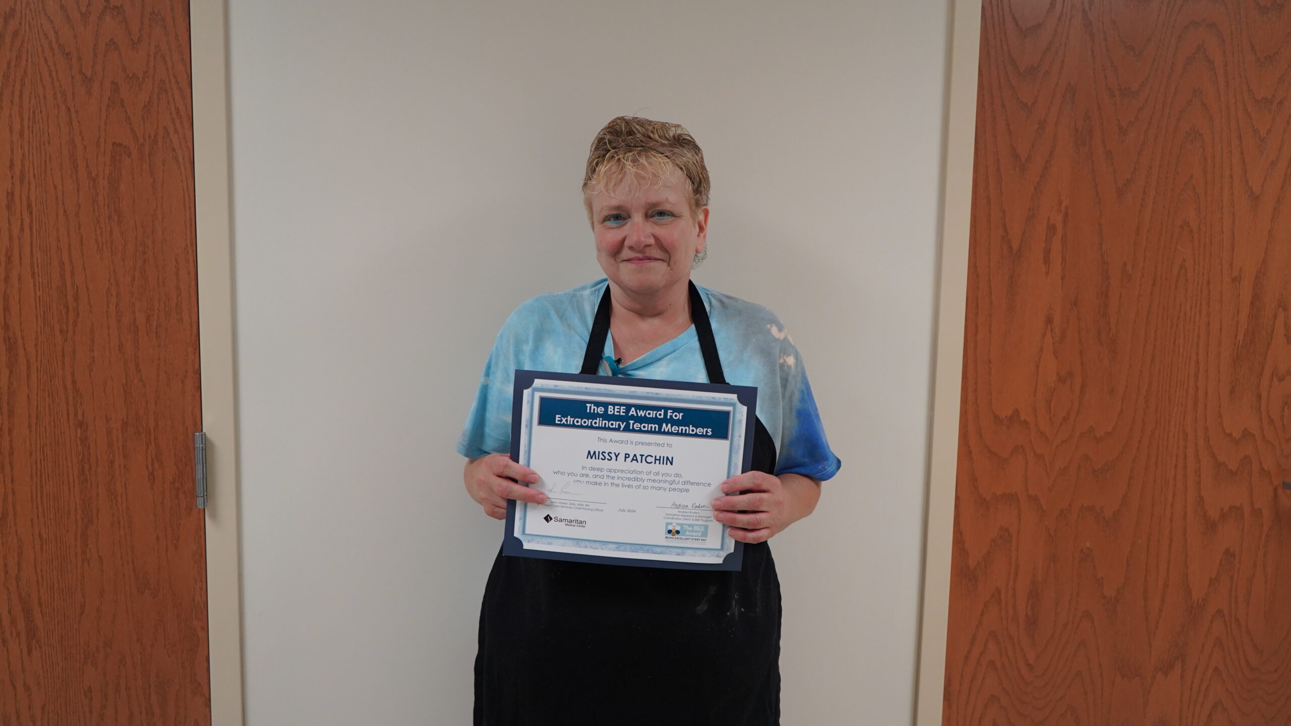 Photo of Missy Patchin, dietary team member, holding her BEE Award certificate for July 2024