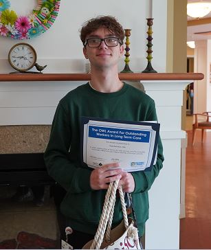 Gage Bell-Shaw, Certified Nursing Assistant, holds his OWL Award certificate.