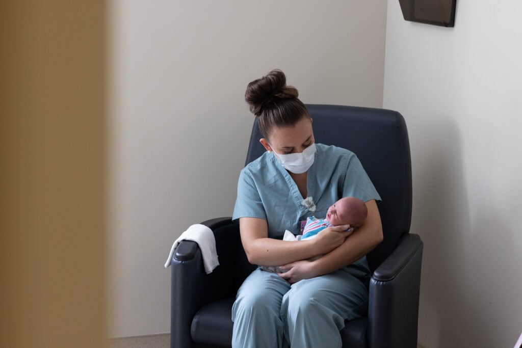 Patient Care: nurse holds a baby in a Samaritan Car-Freshner Center for Women and Children room.