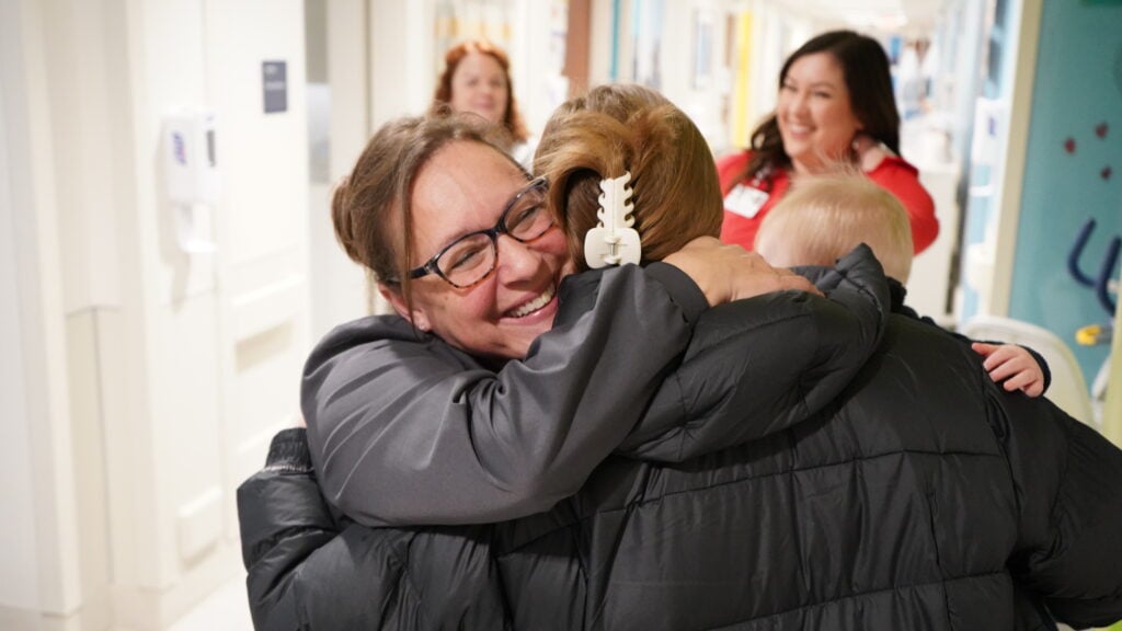 Anne Tyler, RN, hugs a patient