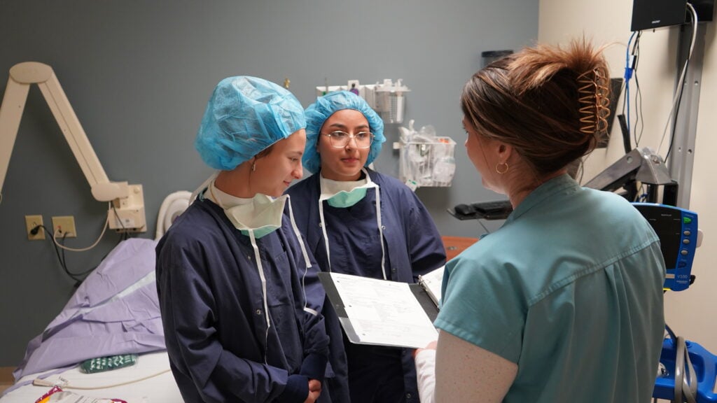 Photo of two MASH Camp Students learning with a nurse