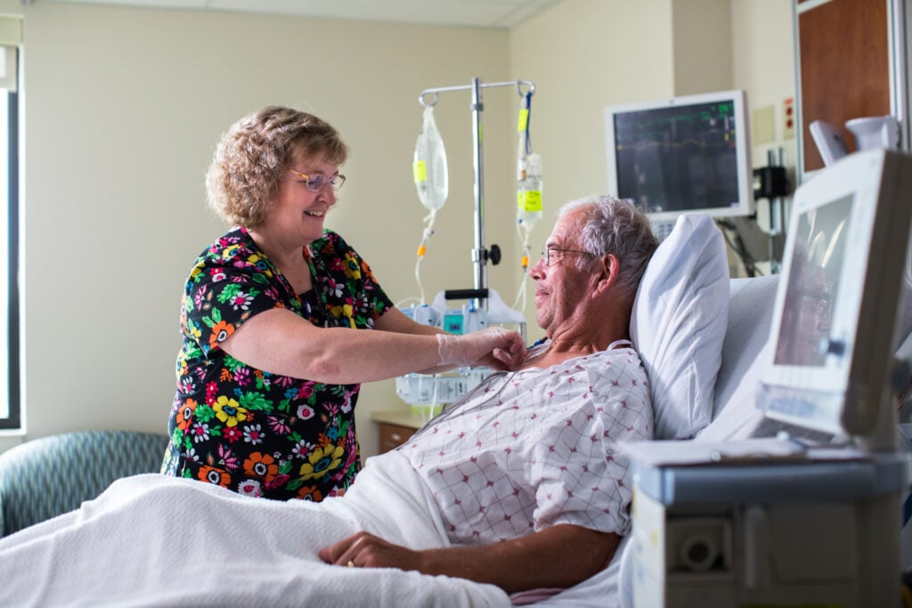 Nurse Shirley Ward checks on a patient in their hospital bed at Samaritan Medical Center