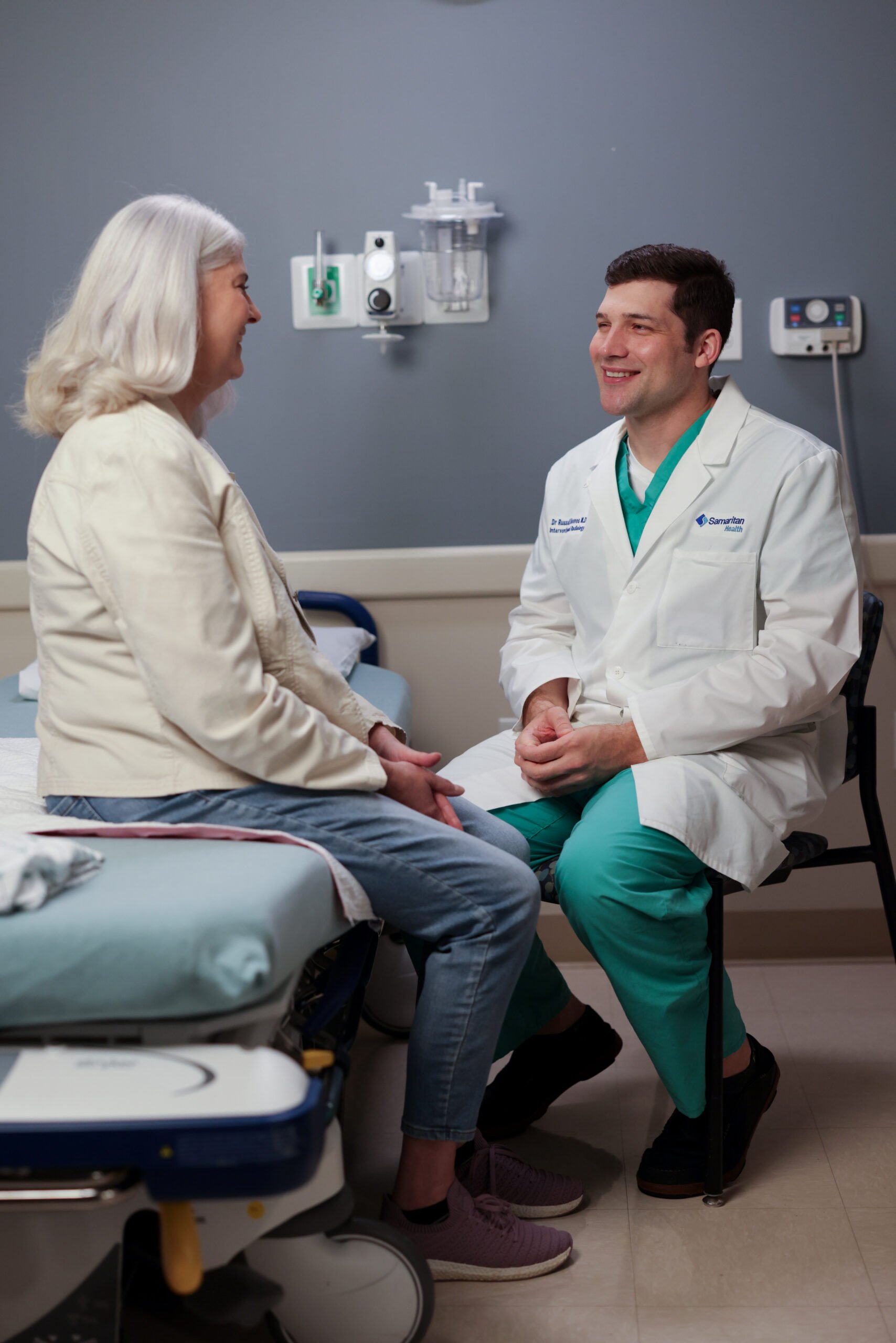 Photo of Dr. Russell Reeves, interventional radiologist, with a female patient on a bed