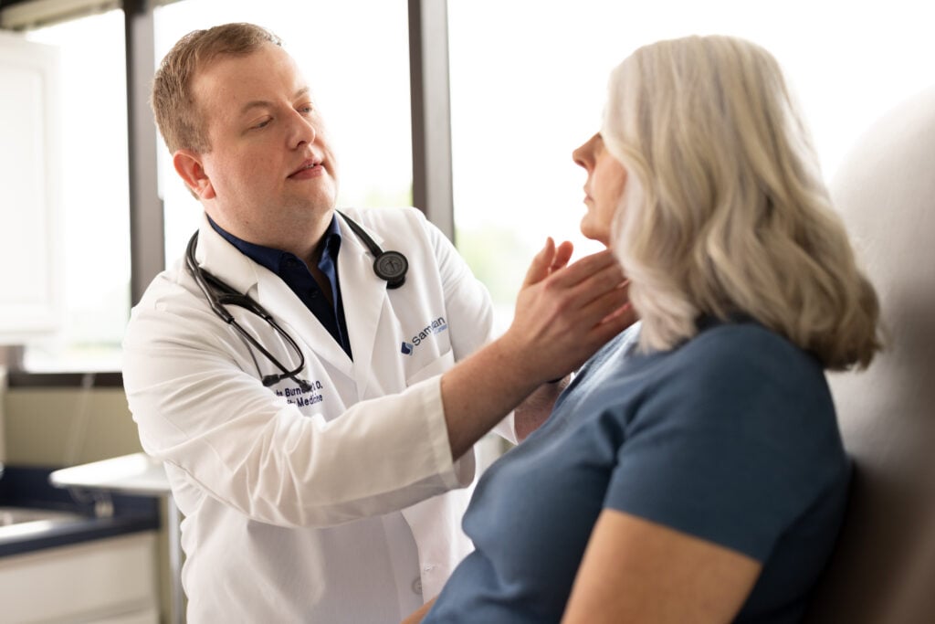 photo of Dr. Burnett, LeRay primary care physician, performing a check-up on a patient