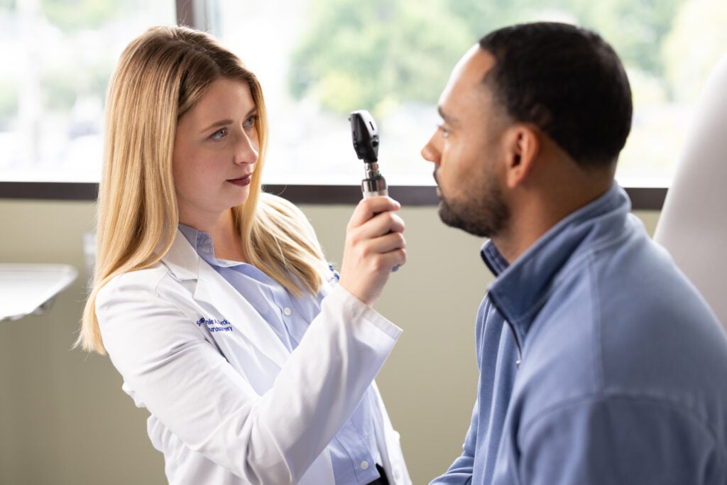 Photo of Dr. Stephanie Zyck, neurosurgeon performing an exam on a patient