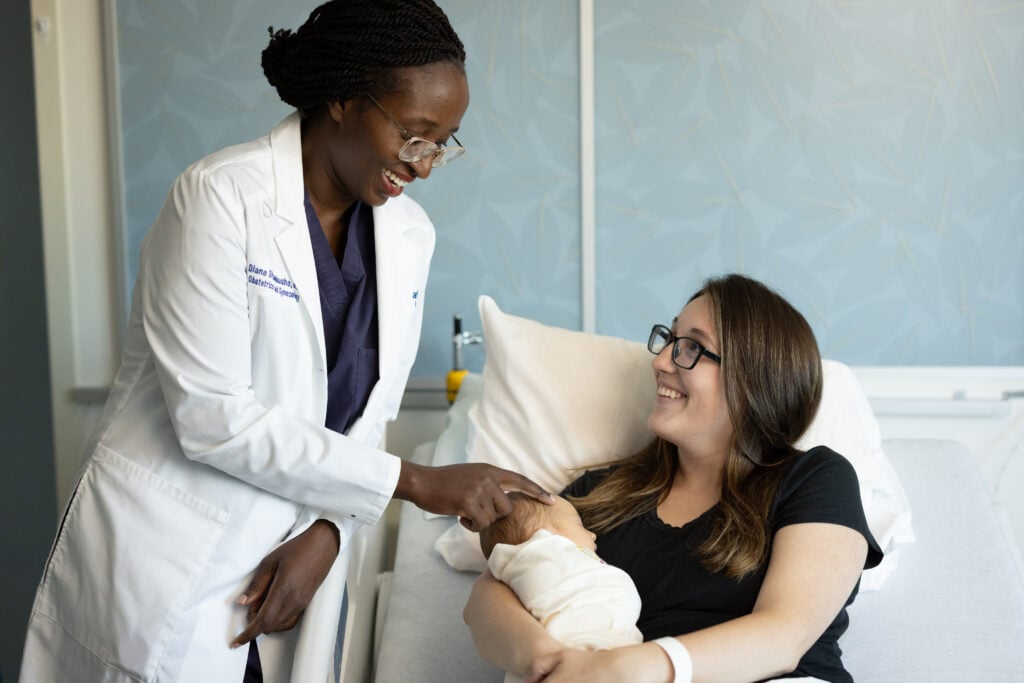 Photo of a mother and baby at the Car-Freshner Center for Women and Children with Dr. Shumbusho