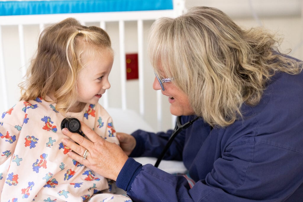 Photo of a pediatric patient with a nurse in the Pediatric Ward at the Car-Freshner Center for Women and Children