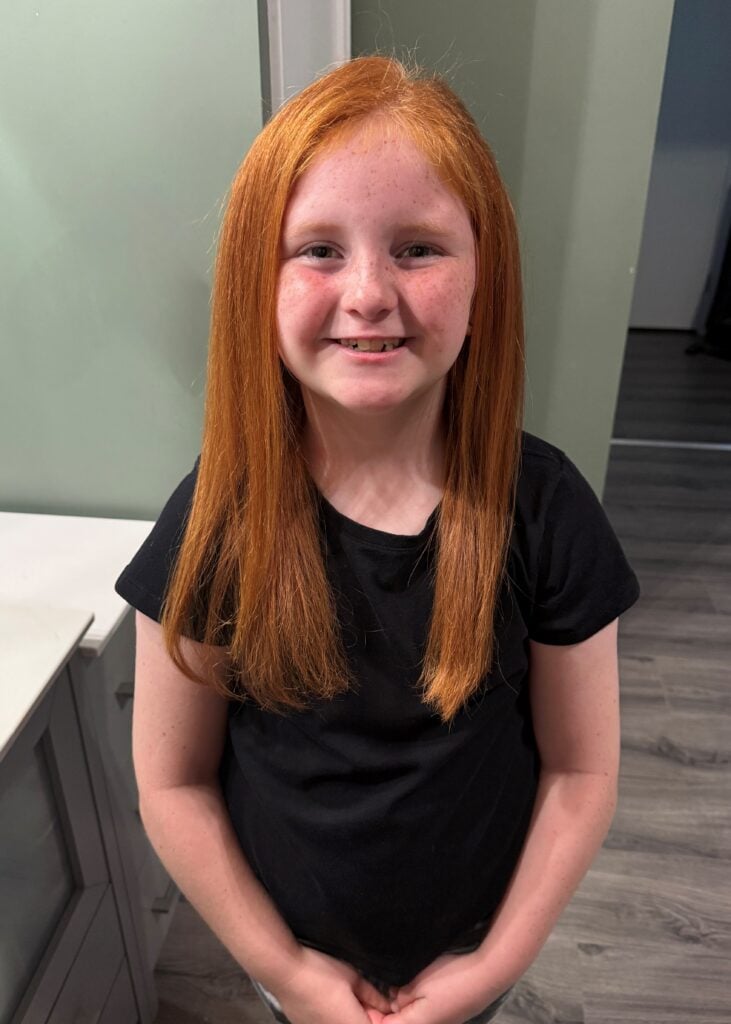 A young girl, Brenley, smiles for a picture.