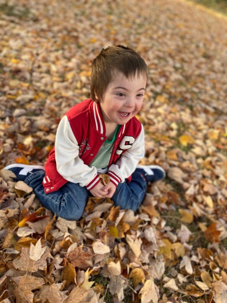 A young boy, Viggo, sits in a pile of leaves