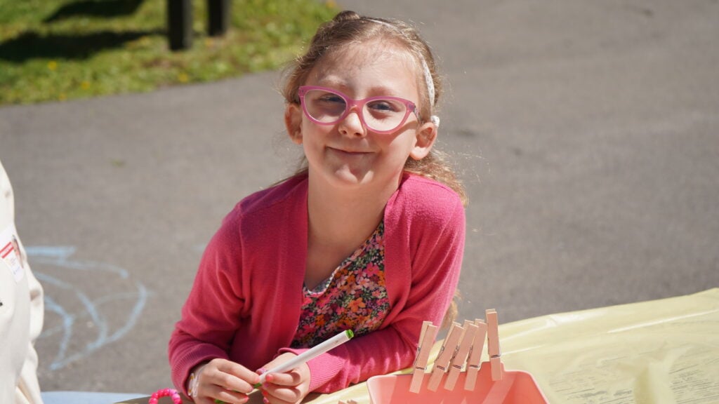 A young girl, Leah, smiles at a CMN event
