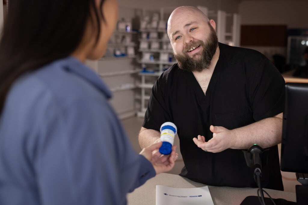 A pharmacy technician assists a customer