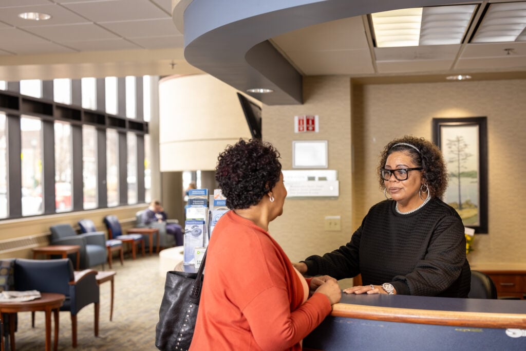 Kim, a Samaritan visitation and screening specialist, greets a visitor at the front entrance