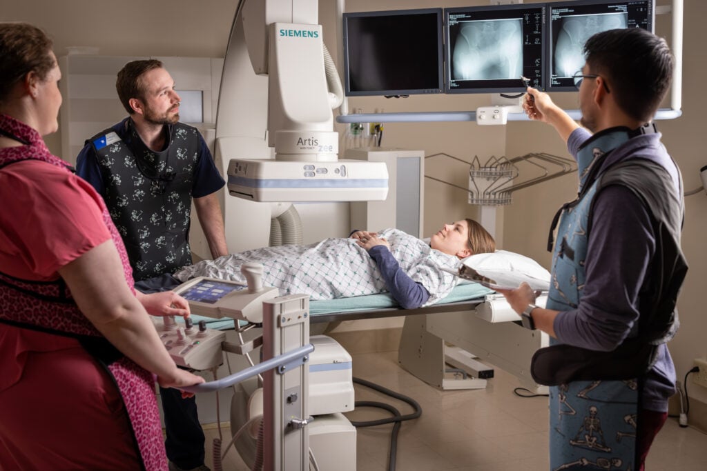 Three radiology technicians review an image