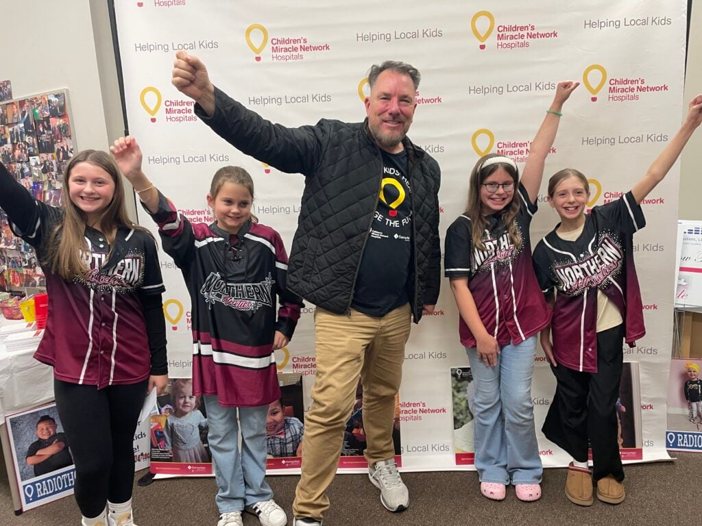 The Border DJ Johnny Spezzano poses with children during Radiothon.